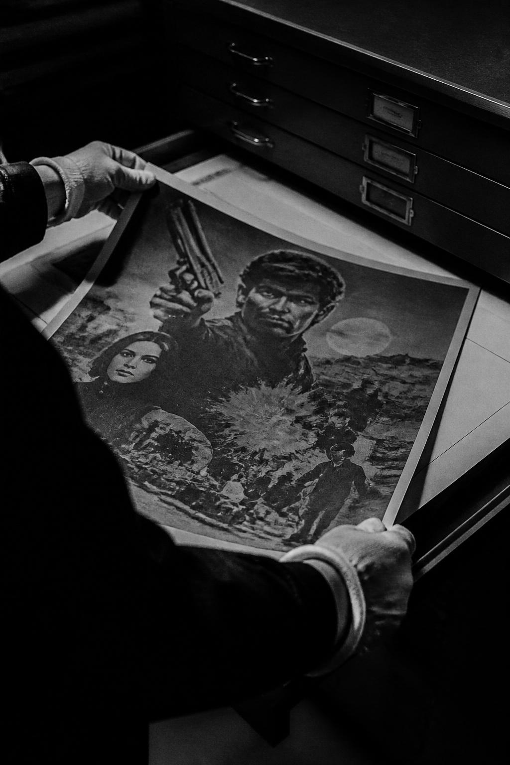 Archivist's gloved hands handling a vintage cinema poster